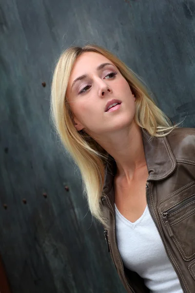 Blond woman leaning on black wall — Stock Photo, Image