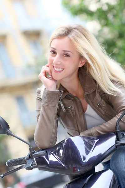 Motosiklet üzerinde oturan sarışın bir kadın gülümsüyor — Stok fotoğraf