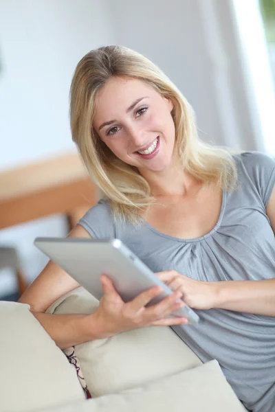 Mujer joven usando tableta electrónica en sofá —  Fotos de Stock
