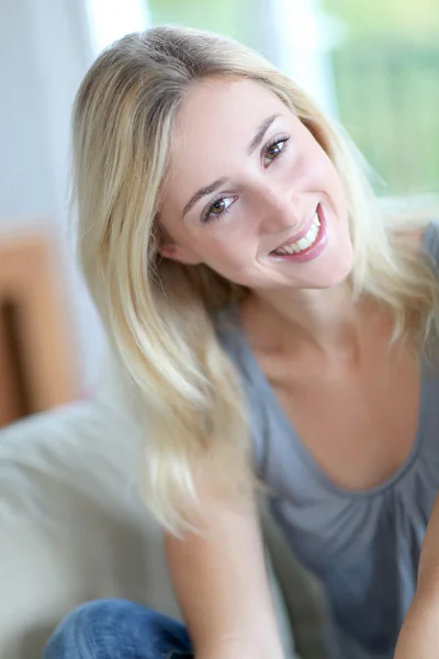 Beautiful smiling woman relaxing in sofa — Stock Photo, Image