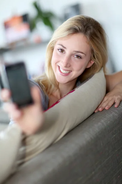 Smilng kobieta pokazano smartphone wobec aparat fotograficzny — Zdjęcie stockowe