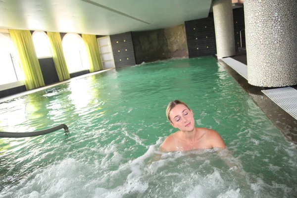 Femme blonde relaxante dans l'eau du spa — Photo