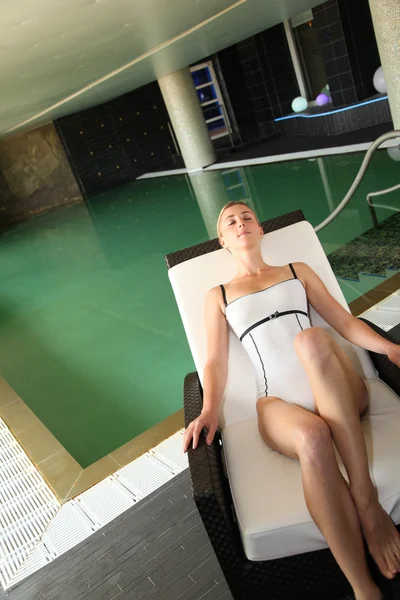 Женщина отдыхает в шезлонге у бассейна — стоковое фото