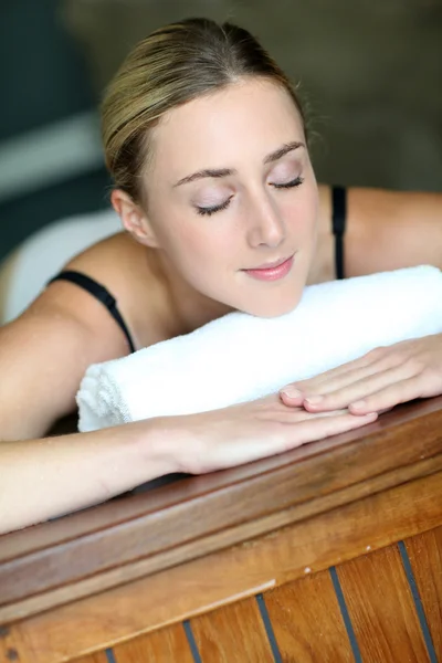 Mujer joven relajándose en la mesa de masaje — Foto de Stock