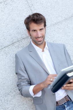 yakışıklı adam elektronik tablet ile duvara yaslanmış