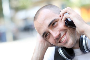 gülümseyen adam sokakta müzik dinlemek