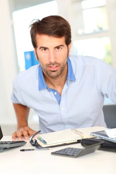 Trabalhador de escritório sentado em sua mesa — Fotografia de Stock