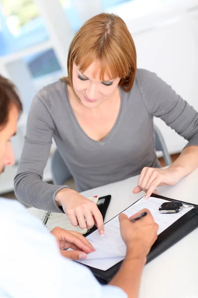 Car buyer sigining contract in office — Stock Photo, Image