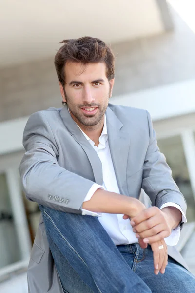 Portrait of businessman sitting outside building — Stock Photo, Image