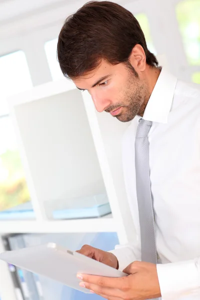 Portret van zakenman in kantoor via elektronische Tablet PC — Stockfoto