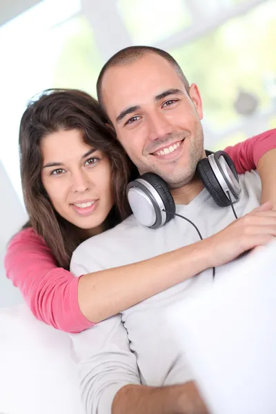 Joven pareja en casa escuchando música en internet — Foto de Stock