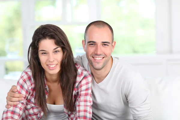 Young couple at home sitting in couch — Stock Photo, Image
