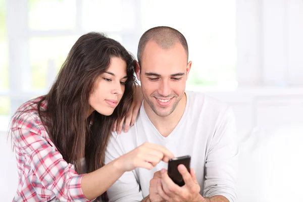 Pareja joven haciendo compras en línea con smartphone — Foto de Stock