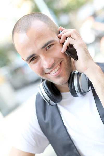 Улыбающийся человек слушает музыку на улице — стоковое фото