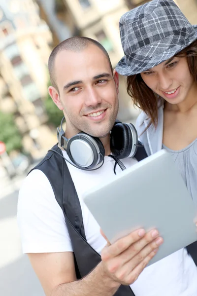 Casal jovem usando tablet eletrônico na cidade — Fotografia de Stock