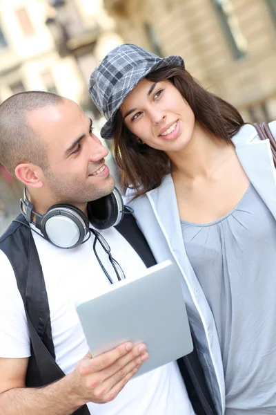 Casal jovem usando tablet eletrônico na cidade — Fotografia de Stock