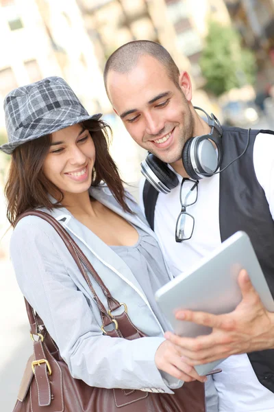 Молодая пара, использующая электронные планшеты в городе — стоковое фото