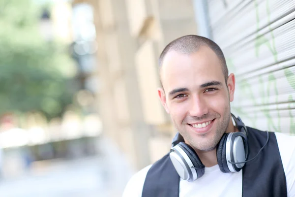Lächelnder Mann hört Musik auf der Straße — Stockfoto