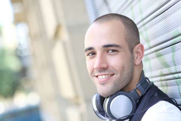 Uomo sorridente che ascolta musica per strada — Foto Stock