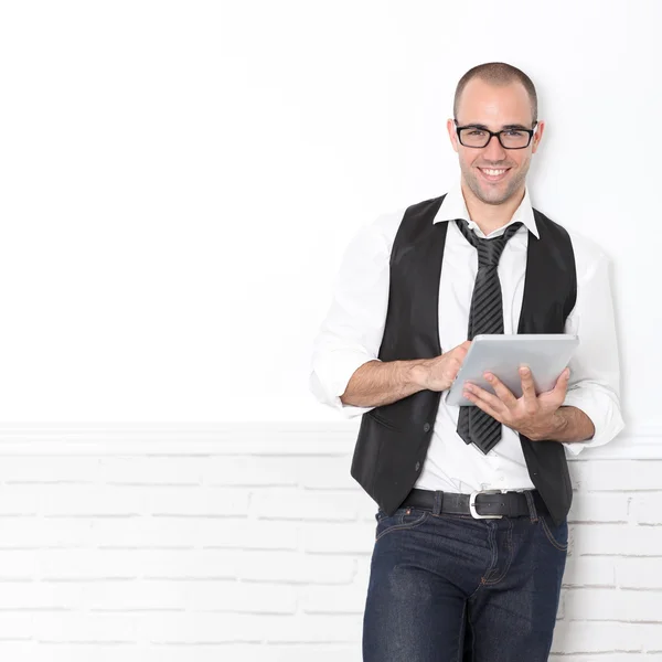 Stylish handsome guy leaning on wall with touchpad — Stock Photo, Image