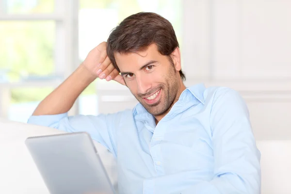 Handsom guy using electronic tablet at home — Stock Photo, Image