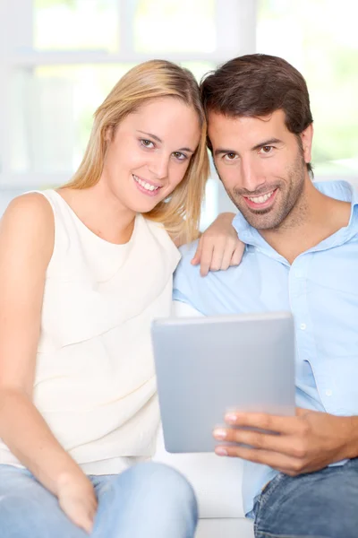 Jong koppel met behulp van elektronische tablet thuis — Stockfoto