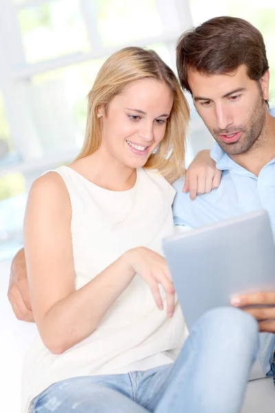 Casal jovem usando tablet eletrônico em casa — Fotografia de Stock