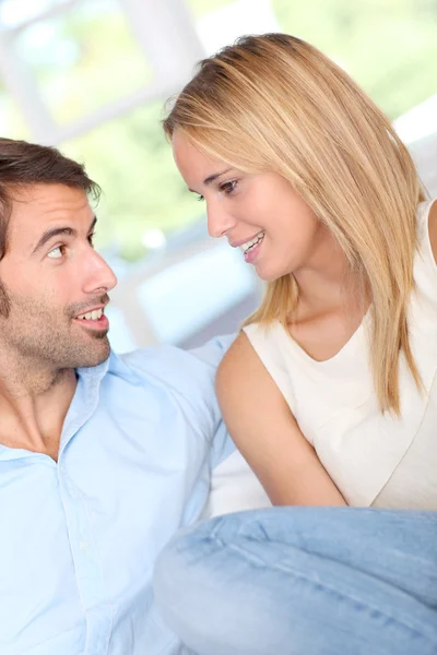 Jovem casal relaxante no sofá em casa — Fotografia de Stock