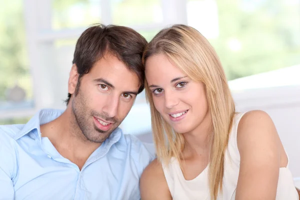 Jovem casal relaxante no sofá em casa — Fotografia de Stock