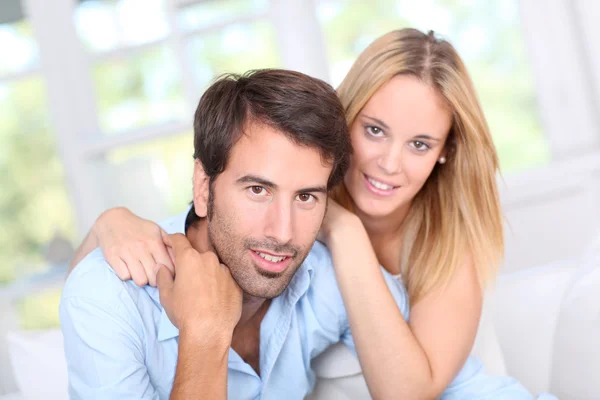 Jovem casal relaxante no sofá em casa — Fotografia de Stock