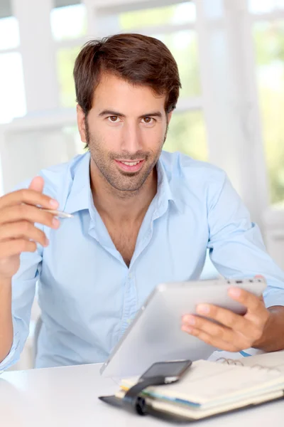 Mann arbeitet im Büro an elektronischem Tablet — Stockfoto