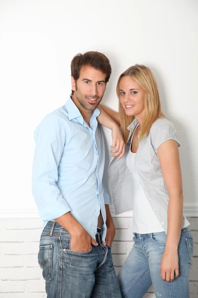 Jeune couple debout sur un mur blanc — Photo