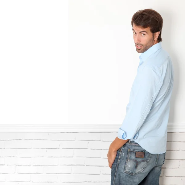 Handsome guy leaning on white wall — Stock Photo, Image