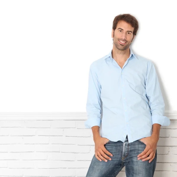 Handsome guy leaning on white wall — Stock Photo, Image
