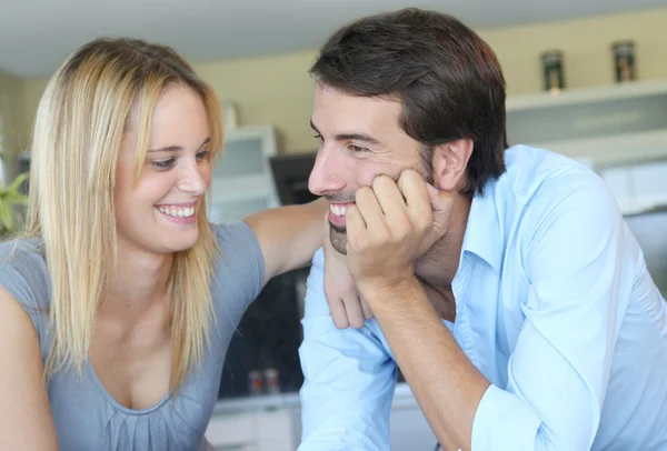 Happy young couple standing in home kitchen — Stock Photo, Image