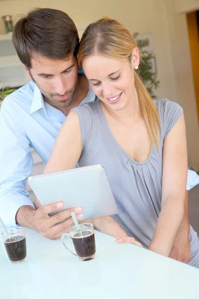 Felice giovane coppia a casa utilizzando tablet elettronico — Foto Stock