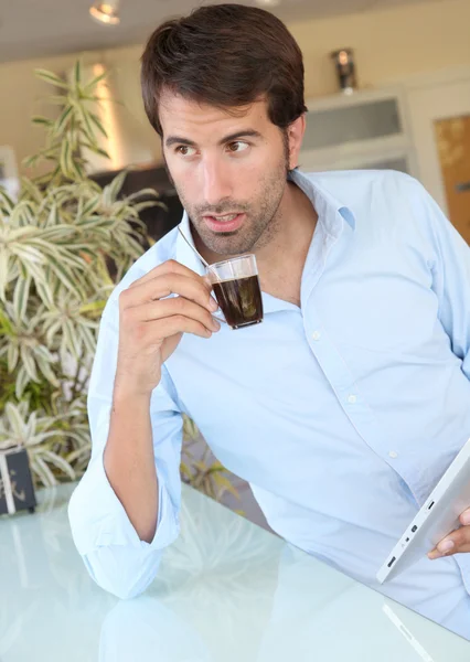 Uomo in piedi in cucina con tablet elettronico — Foto Stock