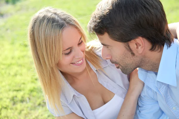 Happy young couple sitting in yard — Stock Photo, Image