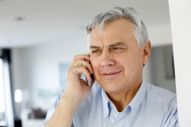 Cep telefonuyla konuşan yaşlı bir adam.