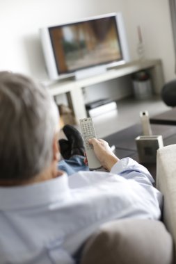 arkadan görünüşü tv izlerken kanepede kıdemli adamı