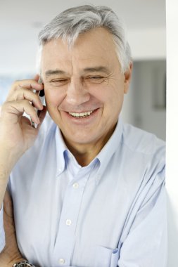 Cep telefonuyla konuşan yaşlı bir adam.