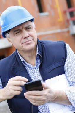 girişimci smartphone kullanarak inşaat sitesinde