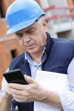 girişimci smartphone kullanarak inşaat sitesinde