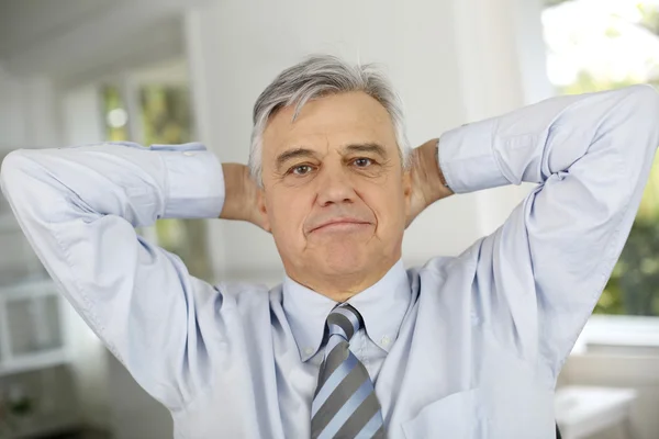 Senior zakenman ontspannen met armen achter hoofd — Stockfoto