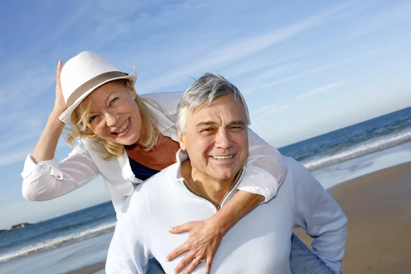 Retrato de casal idoso alegre se divertindo na praia — Fotografia de Stock