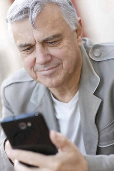 Porträt eines älteren Mannes mit Smartphone in der Stadt — Stockfoto