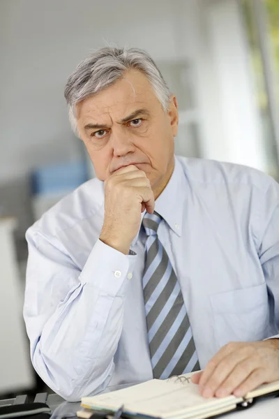 Hombre de negocios senior siendo serio frente al cliente — Foto de Stock