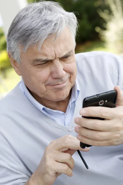 Senior benutzte Smartphone im Garten — Stockfoto