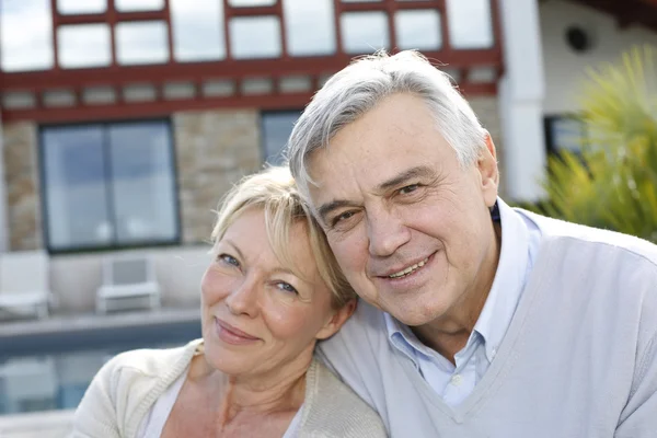 Smiling senior couple standing in home garden — Stock Photo, Image