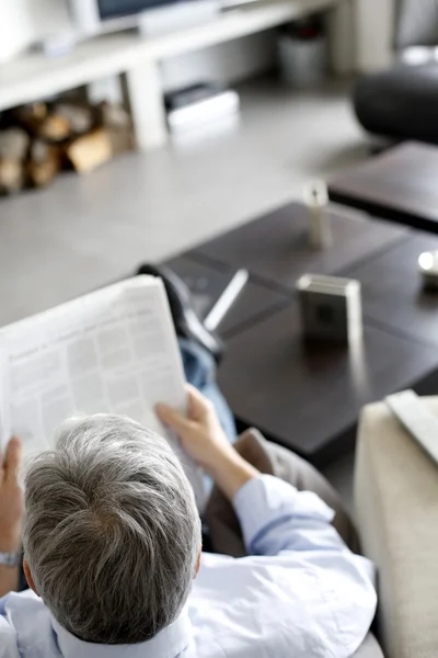 Visão traseira do homem lendo jornal em casa — Fotografia de Stock